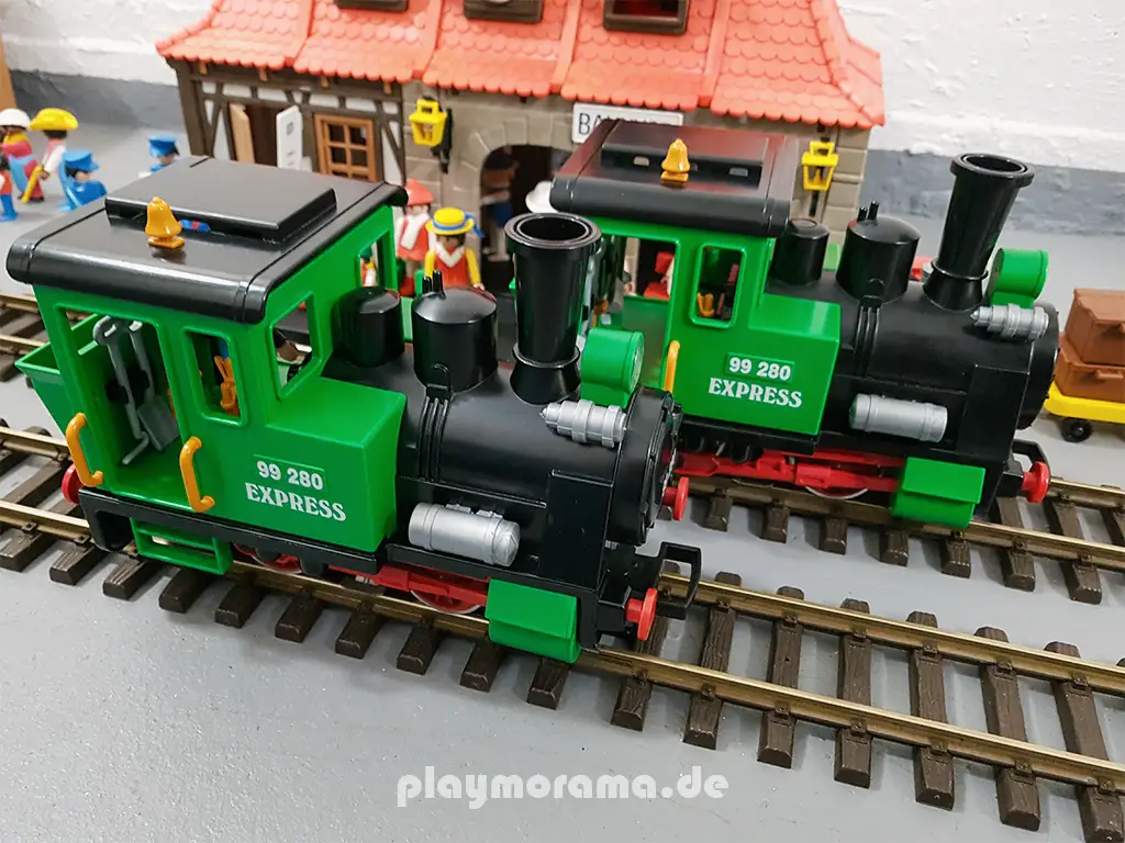 Zwei Dampfloks aus dem Personenzug-Set 4005-A vor dem Playmobil-Bahnhof 4300.