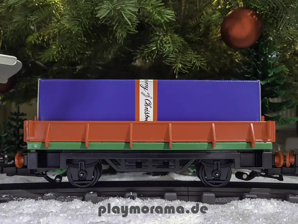 Niederbordwagen im Playmobil Weihnachtszug mit einem Geschenk.