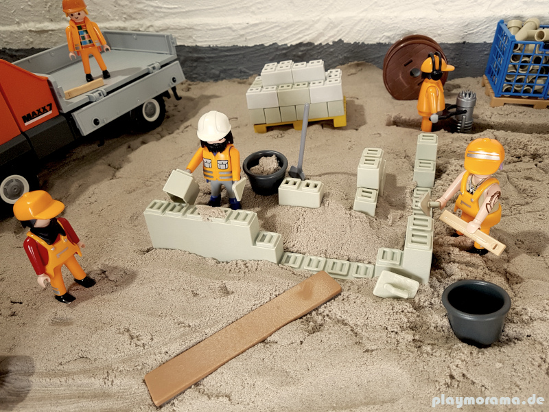 Playmobil Arbeiter mauern eine Mauer für das Fundament.