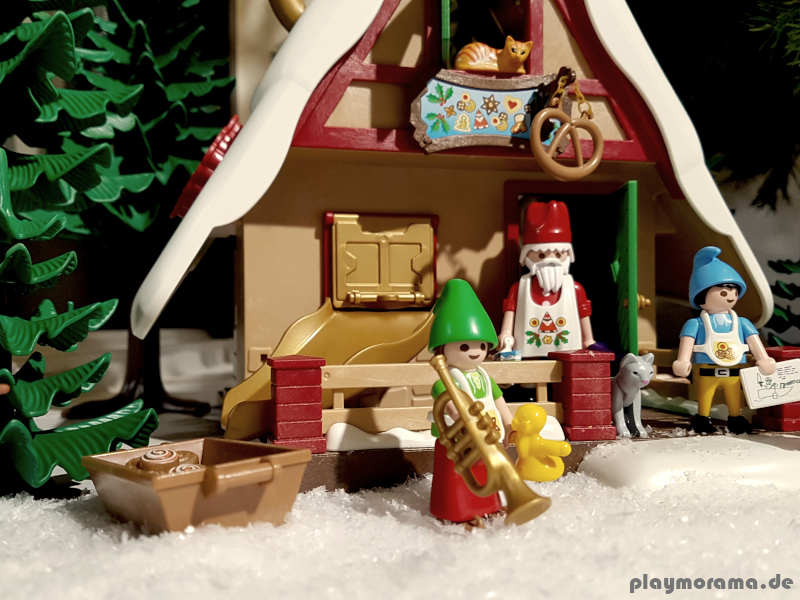 Der Weihnachtsmann mit seinen Heldern vor der Weihnachtsbäckerei mit Plätzchenformen