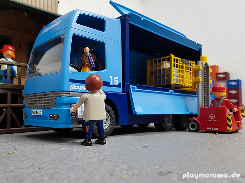 Der blaue Euro Trans LKW bin Playmobil-Aufschrift wird an der Güterabfertigung beladen