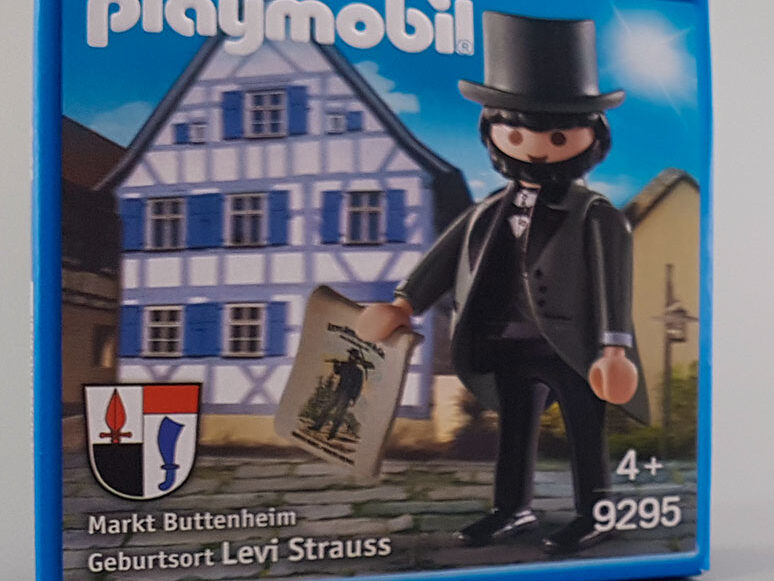 Playmobil Levi Strauss steht vor einem Fachwerkhaus