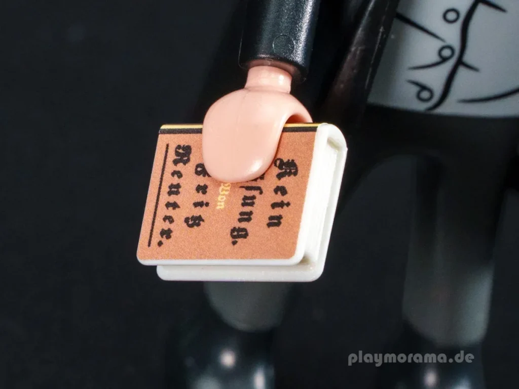 Nahaufnahme des Buches der Playmobil-Figur Fritz Reuter 72111 mit der Aufschrift „Kein Hüsung. Von Fritz Reuter.“